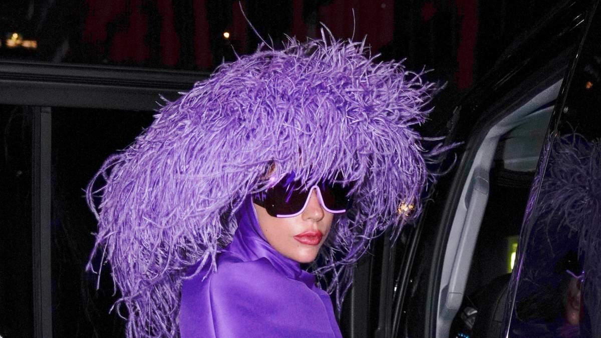 Lady Gaga con un vestido morado y sombrero de plumas de avestruz a juego