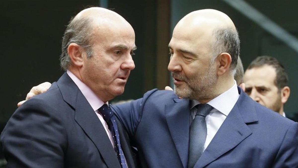 El ministro Luis de Guindos conversa con el comisario de Asuntos Economicos, Pierre Moscovici, en Bruselas el 14 de enero.