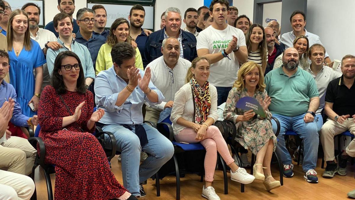 Teresa Mallada, en primera fila con un abanico, entre Agustín Iglesias Caunedo y Reyes Hurlé y rodeada de dirigentes y militantes del PP asturiano,  celebrando el resultado en Andalucía.