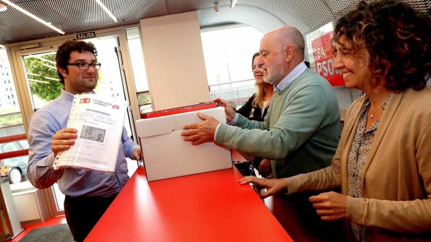 Óscar Pérez, a la izquierda, entrega las cajas con los avales a favor de Barbón en la sede de la FSA.