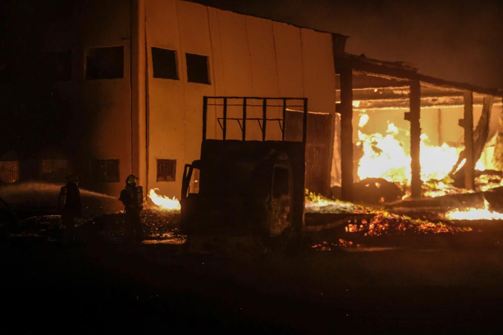 Un espectacular incendio calcina una fábrica de palets en La Marina.
