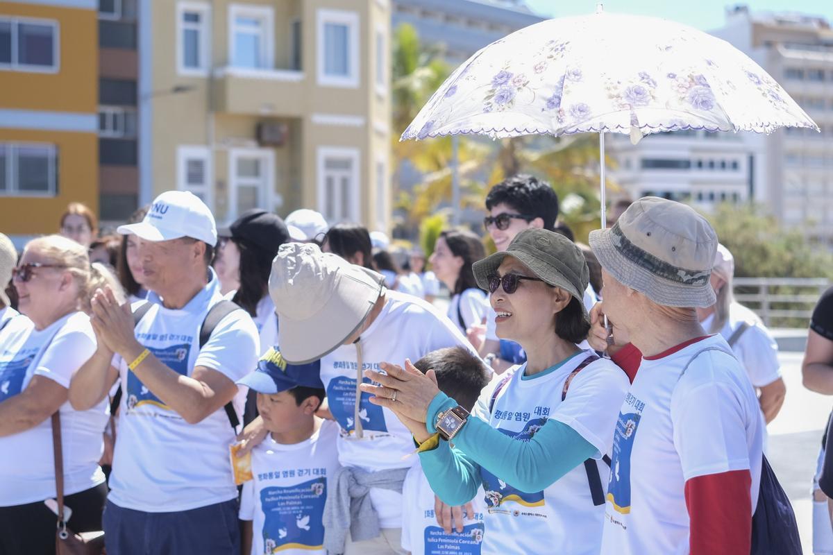 Miembros de la comunidad coreana tras la marcha por el paseo de Las Canteras.