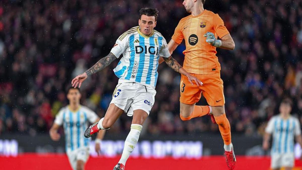 Fonseca salta a disputar un balón con Joan García durante el duelo del Oviedo ante el Barça en el Camp Nou. | SERGIO ROS / FACTORÍA 9