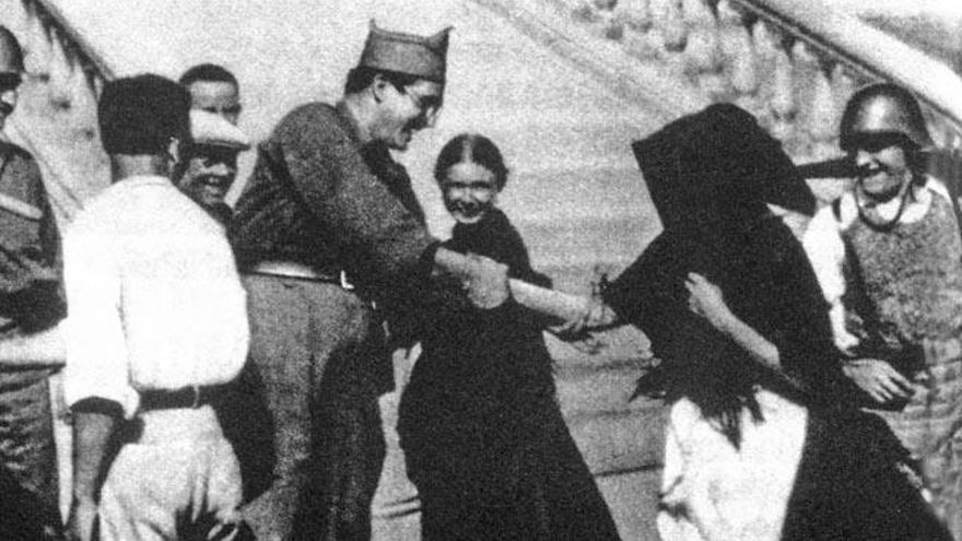 El capitán Uribarry, que se unió desde Valencia a la expedición republicana de Alberto Bayo a Ibiza, saluda a unas mujeres ibicencas bajo la escalera del muro de Ibiza.