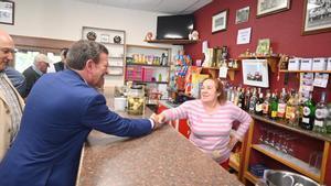 El consejero de la Presidencia de Castilla y León, Luis Miguel González Gago, saluda a una hostelera en su bar de Castromonte (Valladolid).