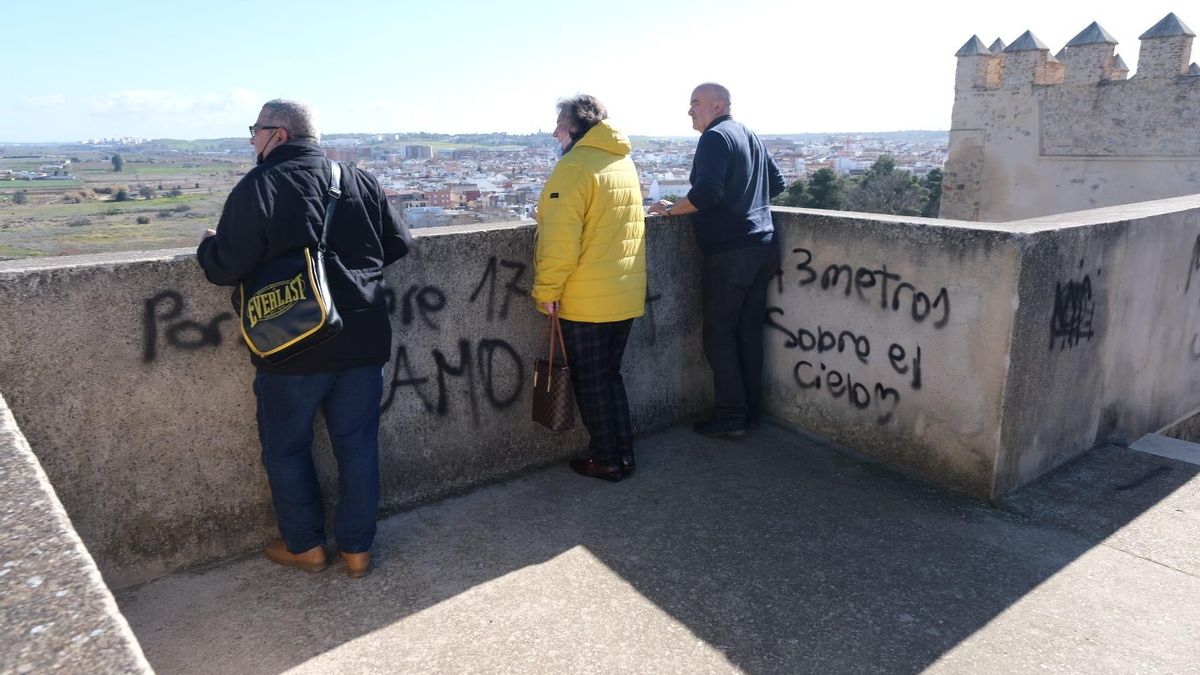 Varios turistas junto a las pintadas realizadas en la alcazaba de Badajoz.