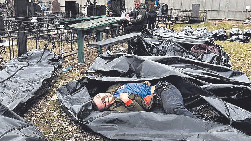 Forenses y bolsas con cadáveres en el cementerio de Bucha, en Ucrania.