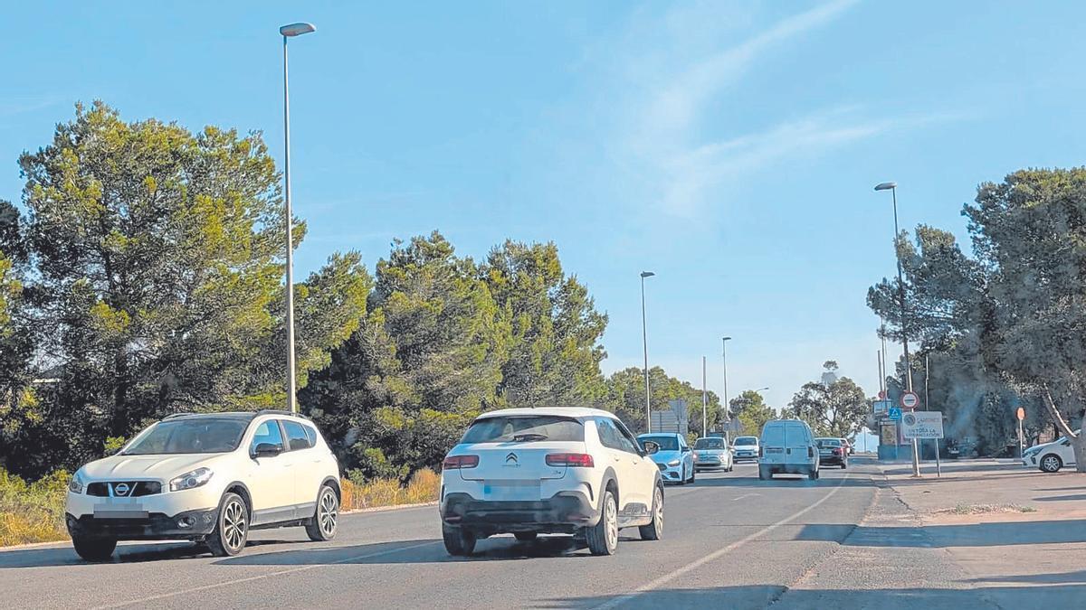 Vehículos a la entrada y salida de la urbanización molinense de La Alcayna a primera hora de la mañana transitando por la carretera.