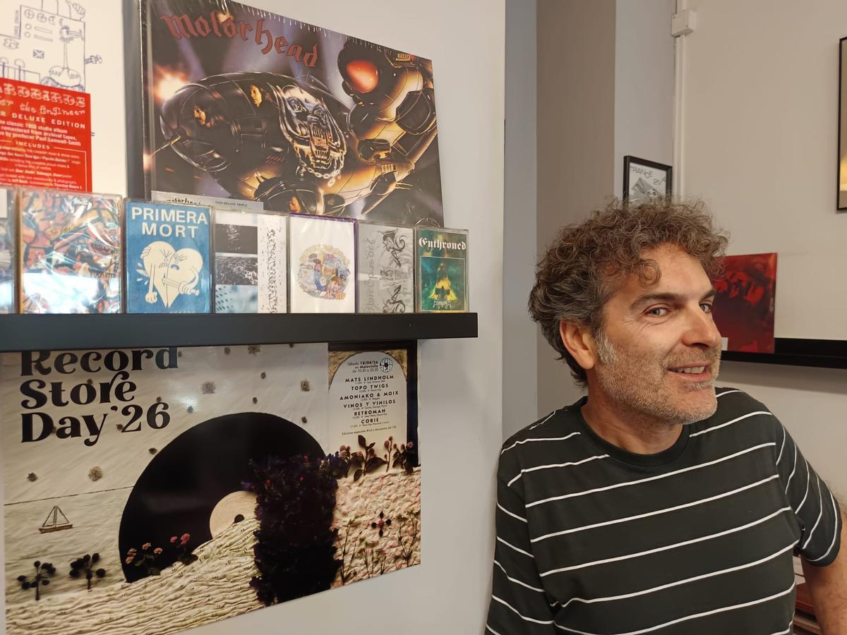 El copropietario de Mais Vinilo posa junto a la programación diseñada para el Record Store Day
