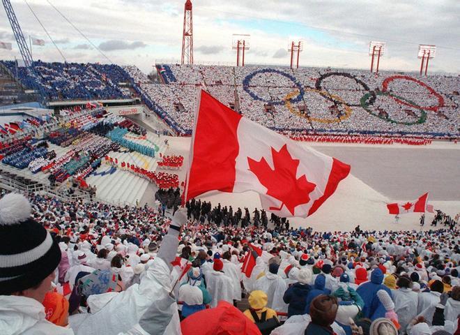 Foto de archivo tomada el 13 de febrero de 1988 los fanáticos aplauden y ondean banderas mientras la delegación canadiense (abajo a la derecha) desfila durante la ceremonia de apertura de los XV Juegos Olímpicos de Invierno en Calgary.