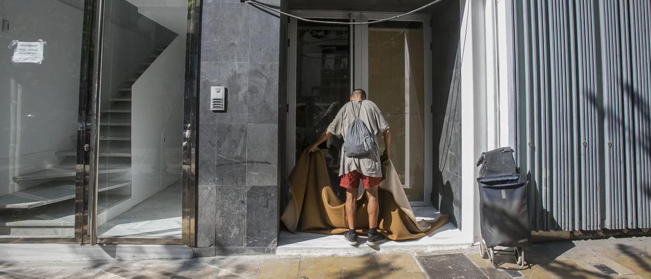 Una persona recoge sus pertenencias, en una céntrica avenida de Alicante