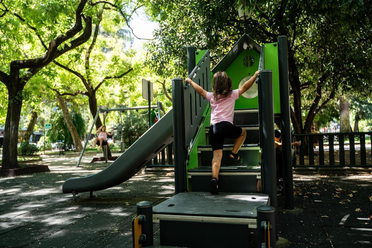 Una niña pequeña disfruta en un parque infantil.