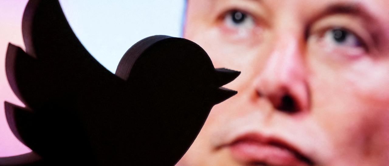 Elon Musk, tras el logotipo de Twitter.