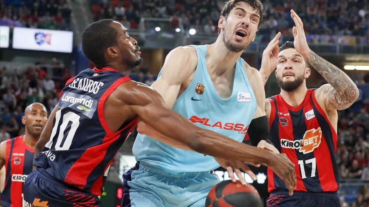 El azulgrana Tomic pugna con el pívot del Baskonia Poirier y el base Beaubois en una acción del partido