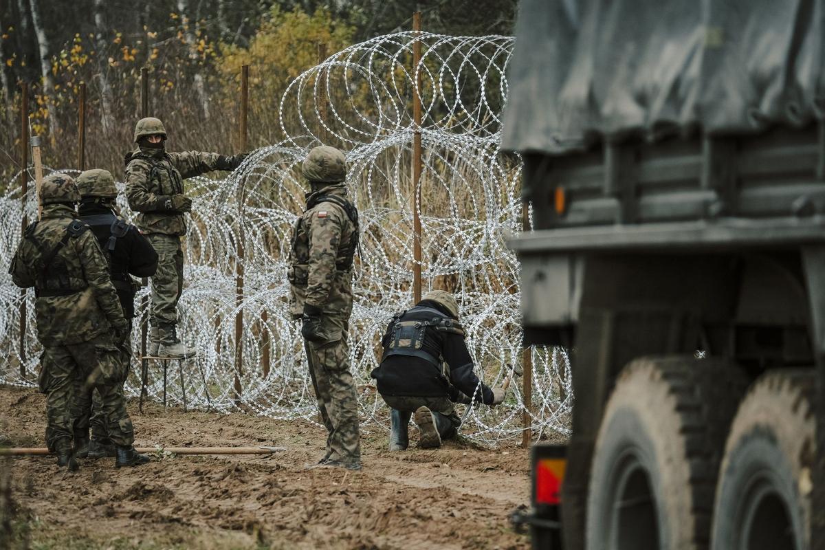 Soldados del ejército polaco arreglan bobinas de alambre de púas en una valla a lo largo de la frontera polaca, con el enclave ruso de Kaliningrado, cerca de Zerdziny, Polonia