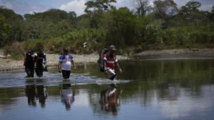 Personas migrantes cruzan el río Tuquesa, en Darién (Panamá), en una fotografía de archivo. EFE/ Bienvenido Velasco