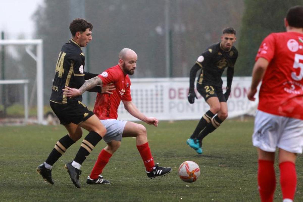 El delantero del Estradense Borja trata de librarse del marcaje de Damián. |  // BERNABÉ/ANA AGRA