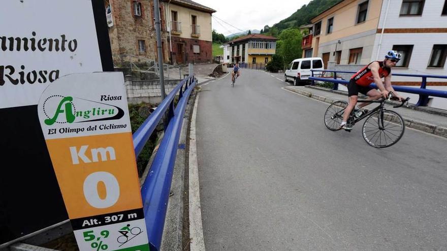 Dos ciclistas, a la entrada del Angliru, cerca de donde se instalará la oficina.