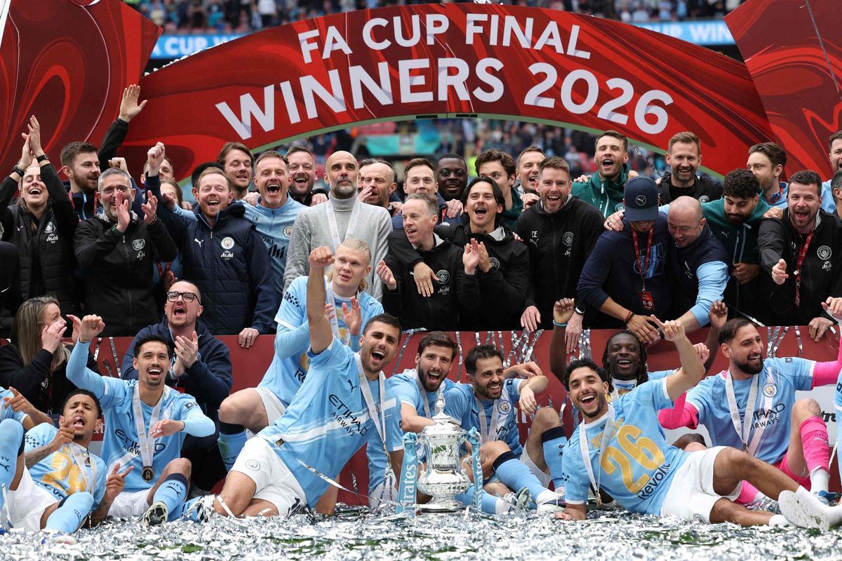 Jugadores y cuerpo técnico del Manchester City celebran con el trofeo en el campo tras la final de la FA Cup inglesa entre el Chelsea y el Manchester City en el estadio de Wembley, Londres, el 16 de mayo de 2026. El Manchester City ganó el partido por 1-0. El tercer título de la FA Cup bajo la dirección de Guardiola puso fin a la racha de dos derrotas consecutivas del City en la final.