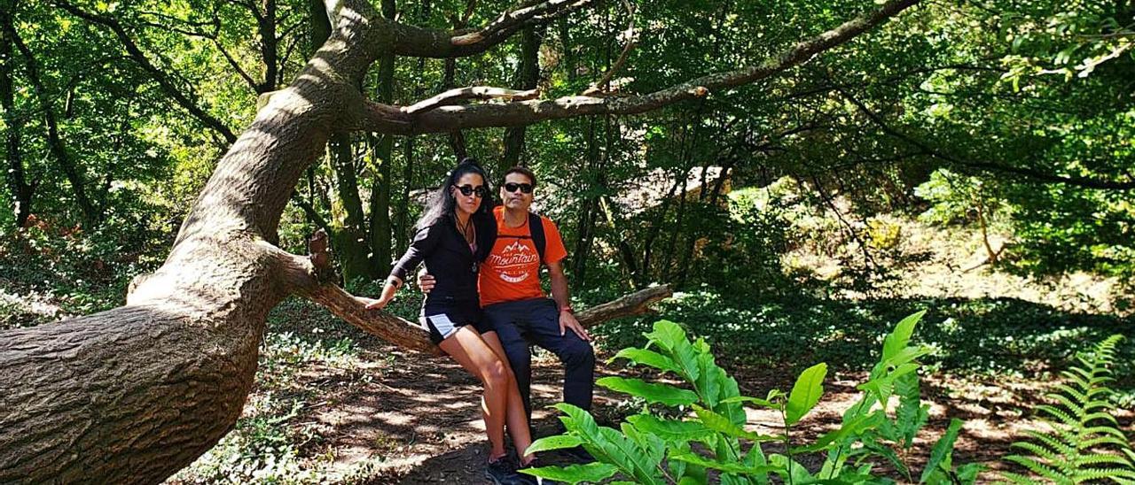 Olalla Garra y Miguel del Valle, durante una ruta, sentados en las ramas de un árbol.