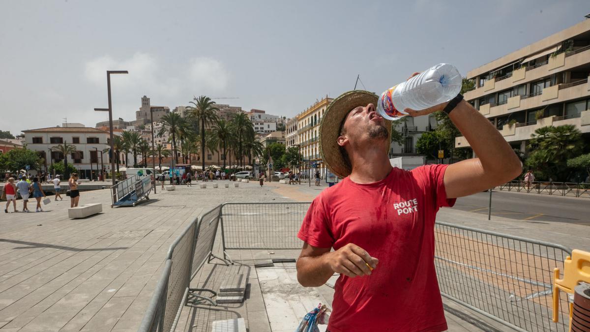 Un treballador beu aigua durant una onada de calor a Eivissa.