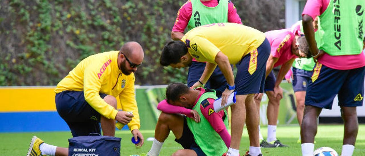 Nauzet Alemán es atendido por un recuperador y Eder Sarabia durante el entrenamiento de ayer bajo la mirada de Roque Mesa y Wakaso.