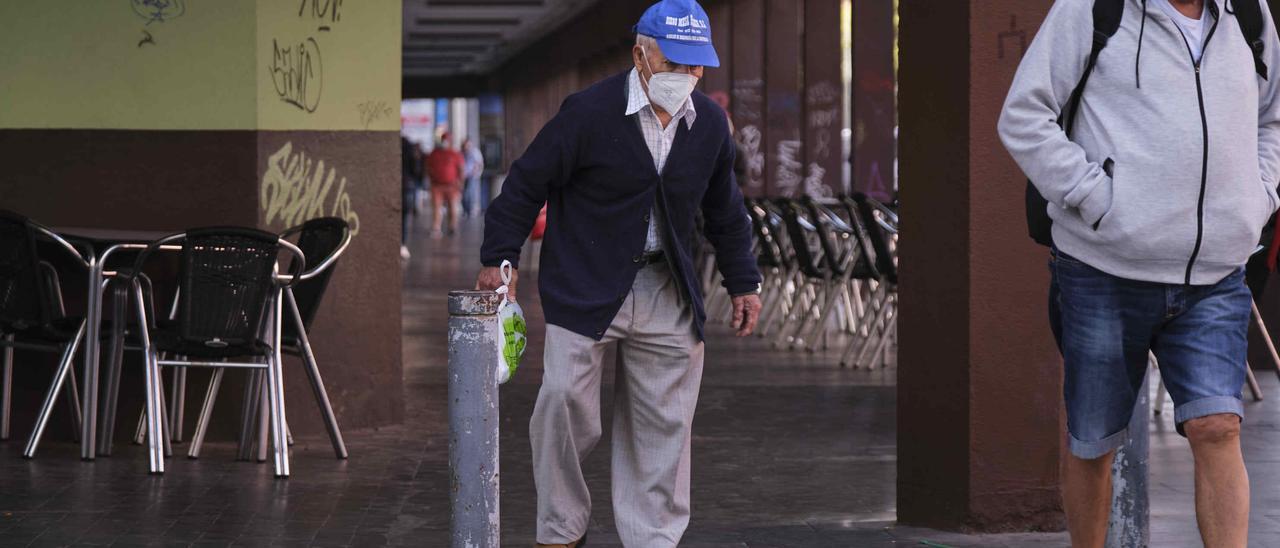 Un jubilado pasea por una calle de La Laguna.