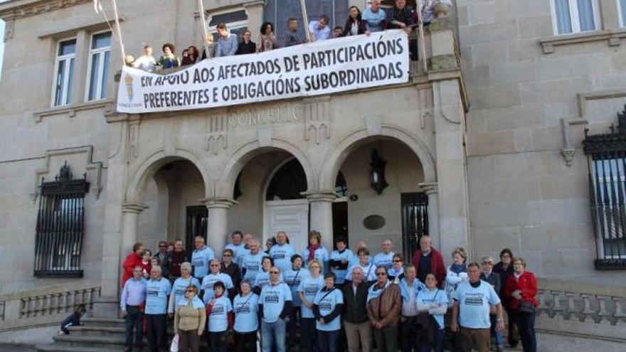 La alcaldesa y los portavoces de los grupos cuelgan una pancarta del balcón consistorial.  // Santos Álvarez
