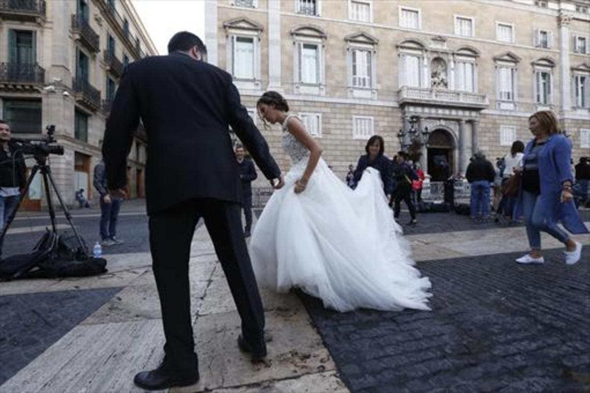 Una pareja de novios cruza la plaza de sant Jaume, ayer.