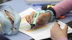 Una alumna de 5º de primaria repasa unos apuntes en clase.