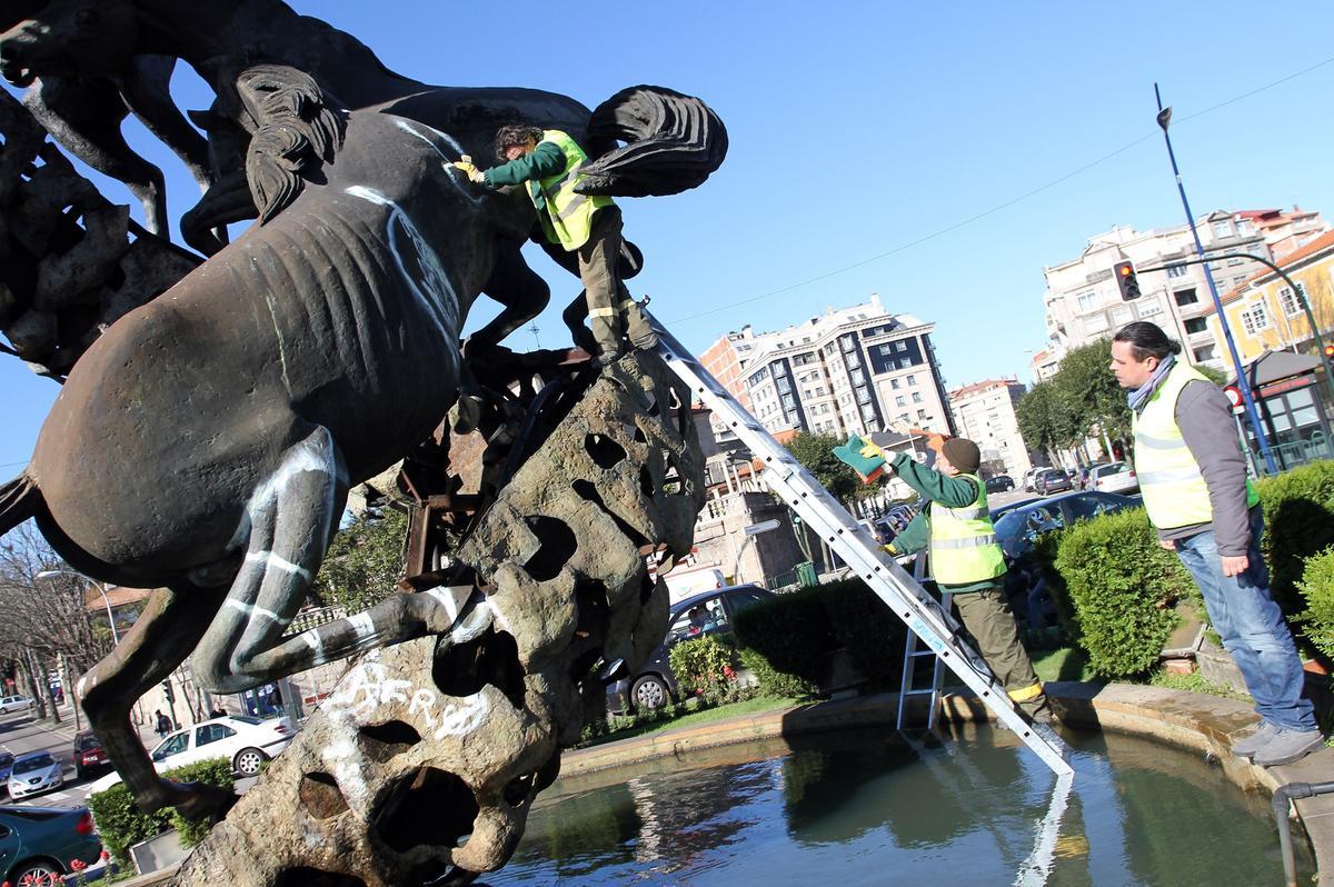 Operarios municipales limpiando el monumento de Juan José Oliveira, que fue pintando en 2011 con rayas blancas.