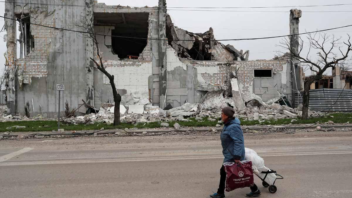 Una dona passa per davant d&#039;un edifici destruït a Mariúpol