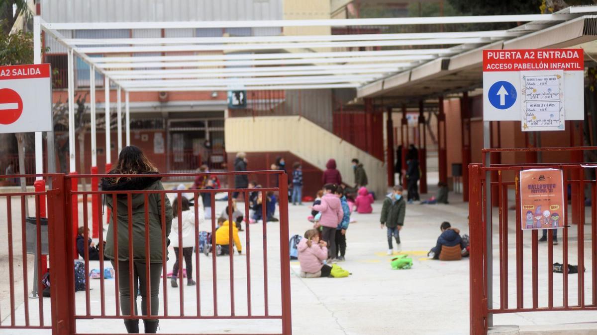 Varios menores esperan a sus padres, ayer, separados entre ellos en el patio.