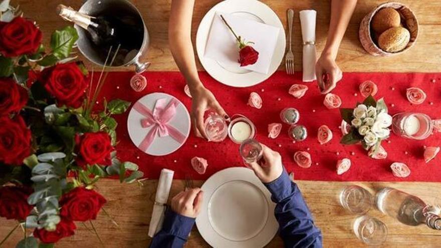 Una pareja celebra San Valentín en la mesa.