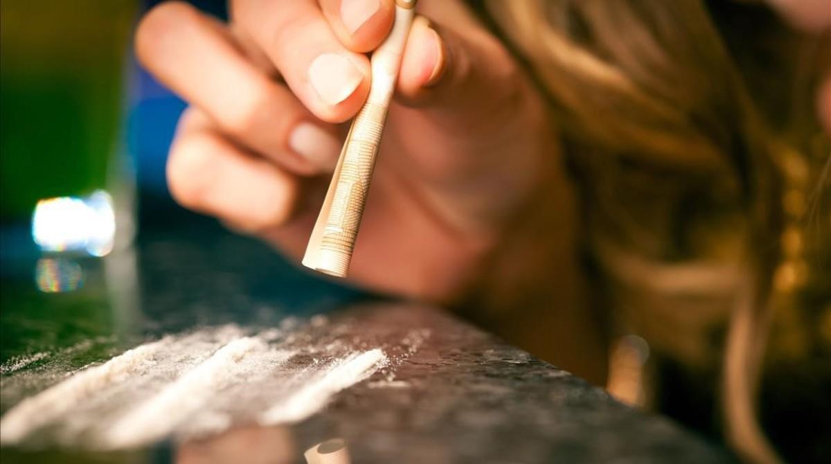 Un consumidor de cocaína esnifa la droga. Un consumidor de cocaína esnifa la droga.