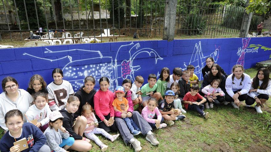 Os participantes posan diante do muro que van decorar.