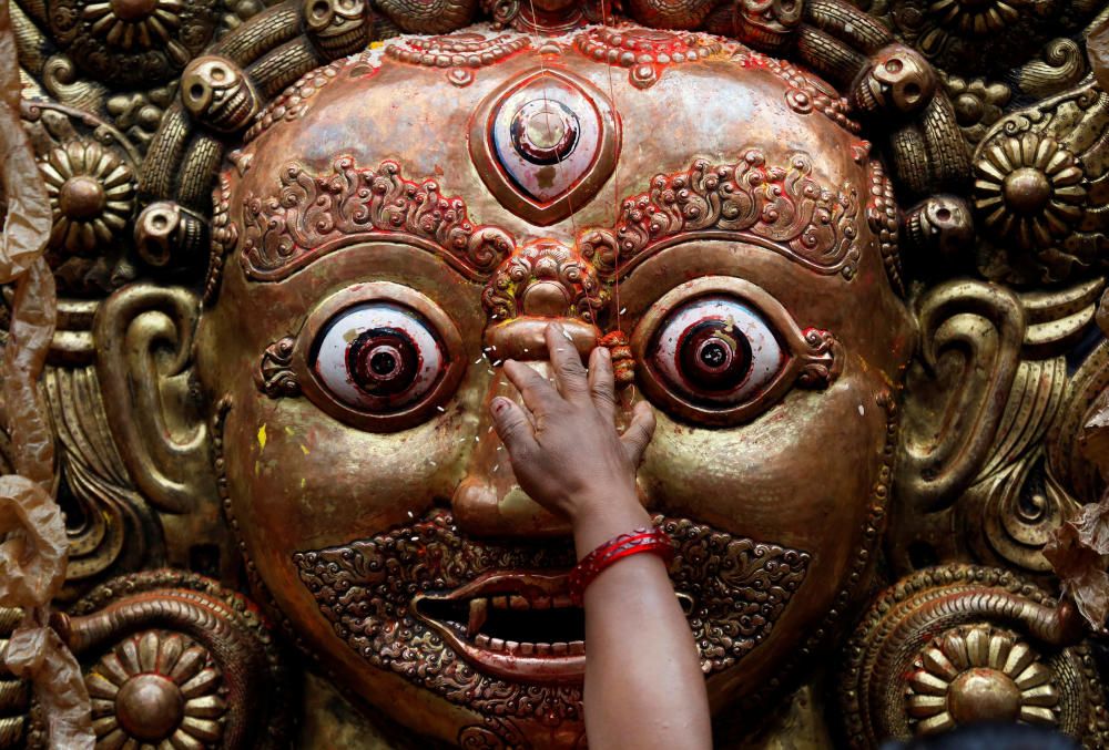 A hand of a devotee is pictured as she sprinkles ...