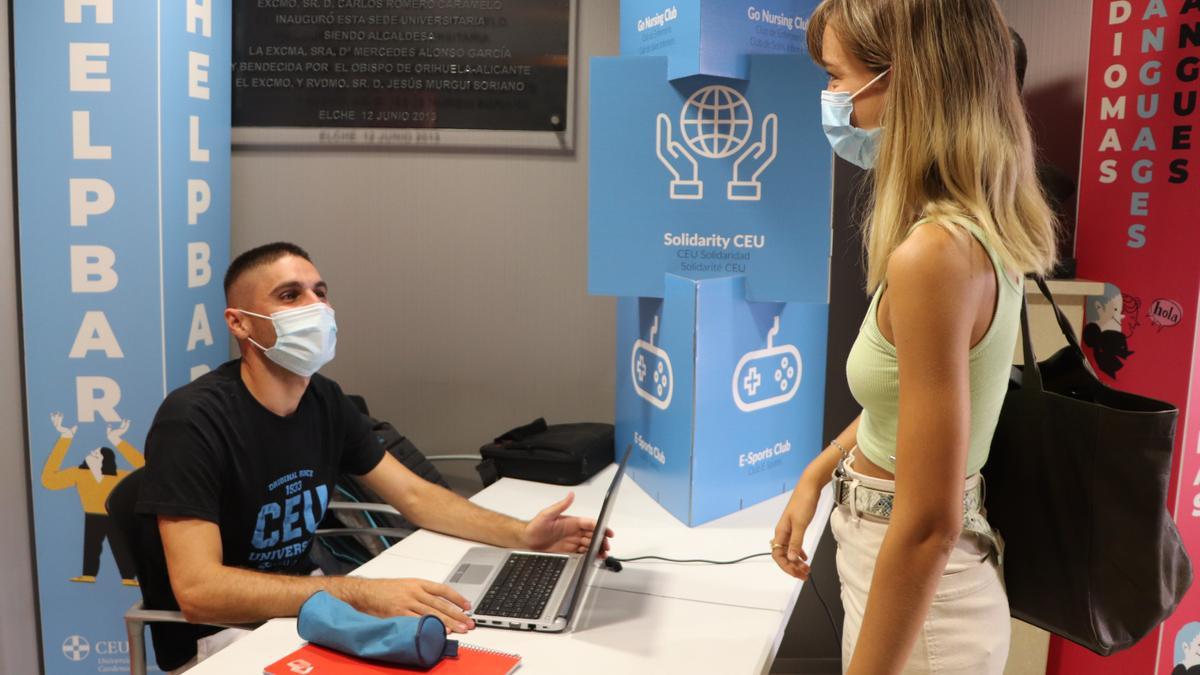 Felipe López, beneficiario de una Beca Merit, atiende a una nueva alumna en sus horas de colaboración con la Universidad.