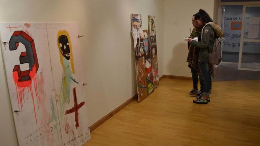 Dos jóvenes contemplan varias de las obras expuestas en Ribadesella hasta el día 15.