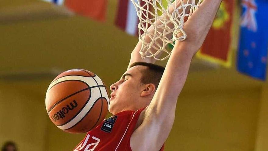 Marko Pekarski se cuelga del aro para anotar una canasta en un partido con la selección sub-18 de Serbia.