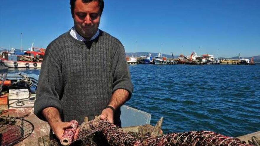 Un bateeiro raspa la semilla del mejillón en las rocas del litoral.  // Iñaki Abella