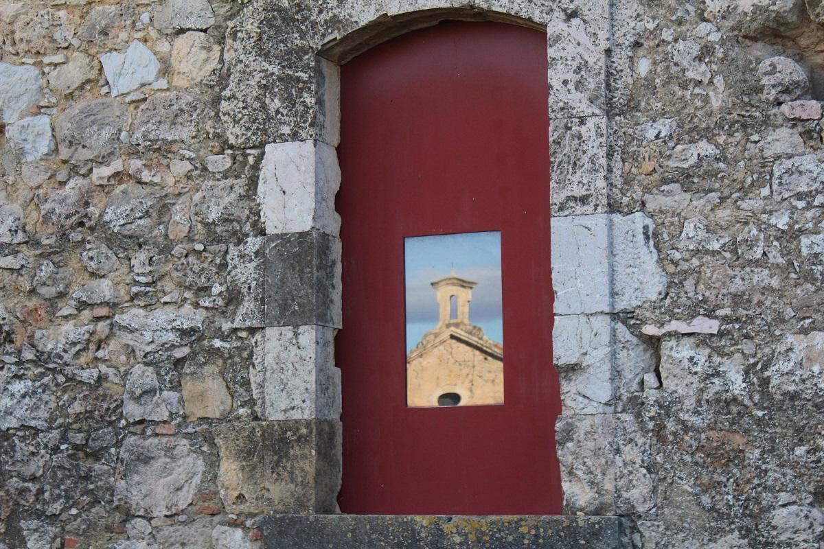 La capella del Castell reflectida en un finestral de la fortalesa.