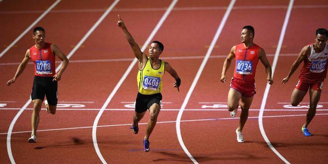 Muhammad Haiqal Hanafi (# 0406) de Malasia compite para ganar en el evento de atletismo masculino de 100 metros en los Juegos SEA (Sudeste Asiático Juegos) en el estadio de atletismo en Clark City, Capas, provincia de Tarlac Manila.