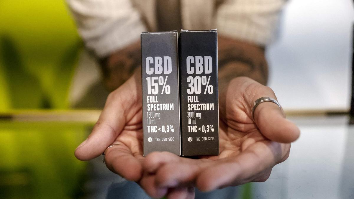 Un empleado de una grow shop de Palma muestra algunos de los productos que contienen cannabidiol en diferentes proporciones.