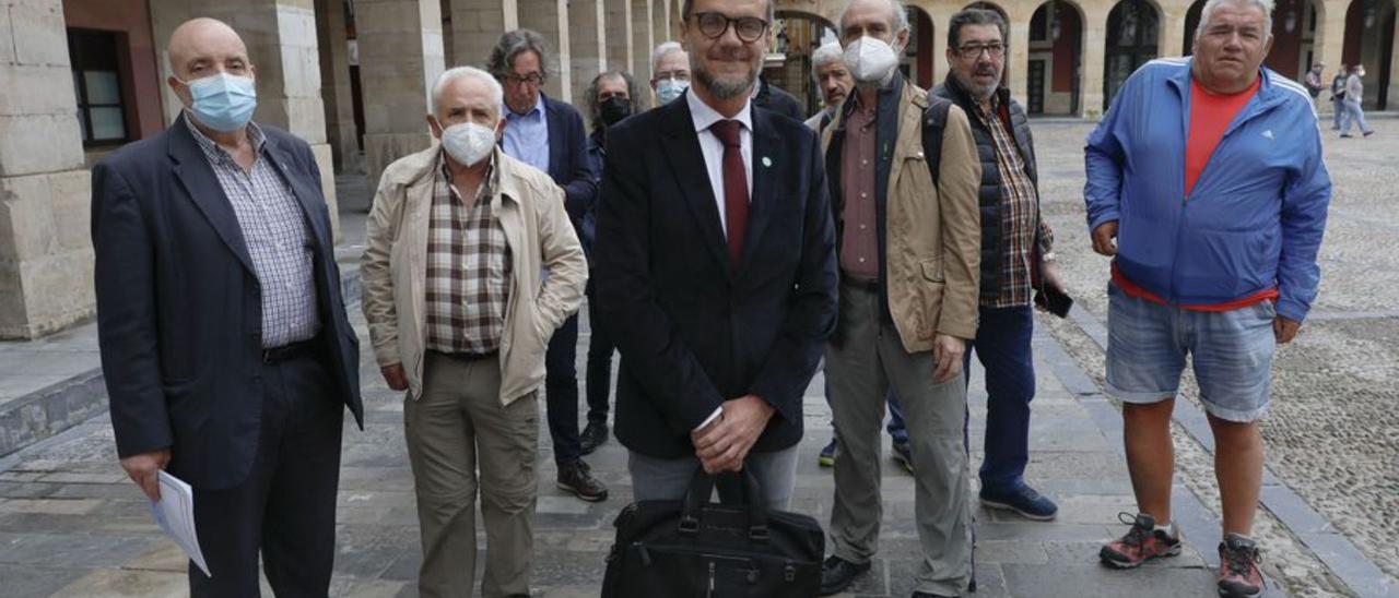 En primer plano, Javier Calzadilla junto a extrabajadores de Naval Gijón. | Marcos León