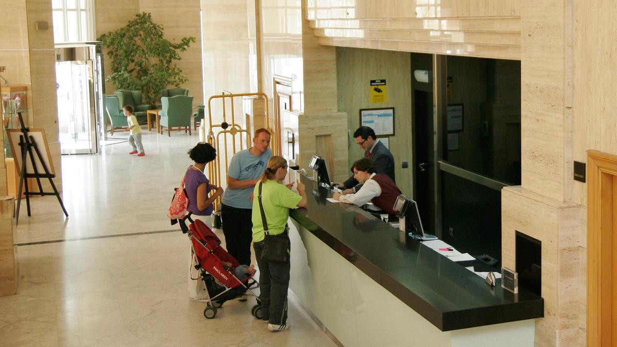 Varios clientes en la recepción de un hotel.