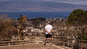 Un hombre observa la isla de Maui, en Hawái, devastada por los incendios.