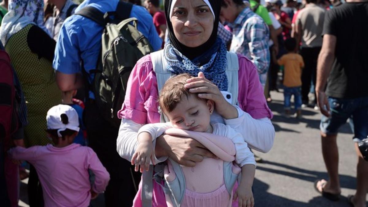 Una refugiada siria con su hija tras llegar a Grecia.