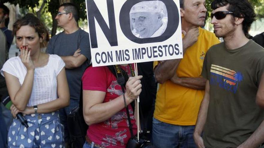 Varias personas protestan hoy contra los descuentos en el transporte público madrileño para los asistentes a la Jornada Mundial de la Juventud.