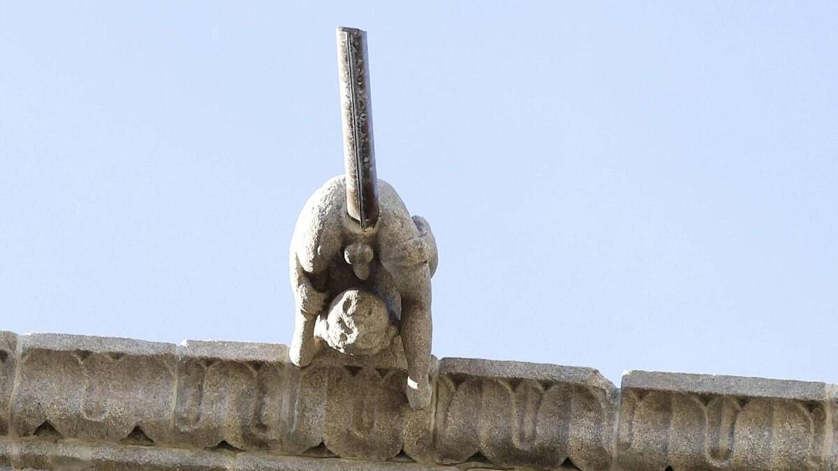 La gárgola que representa a un joven en posición acrobática que expulsa el agua por el ano